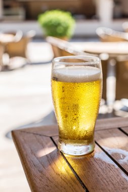 Ahşap masa üzerinde light bira bardak.