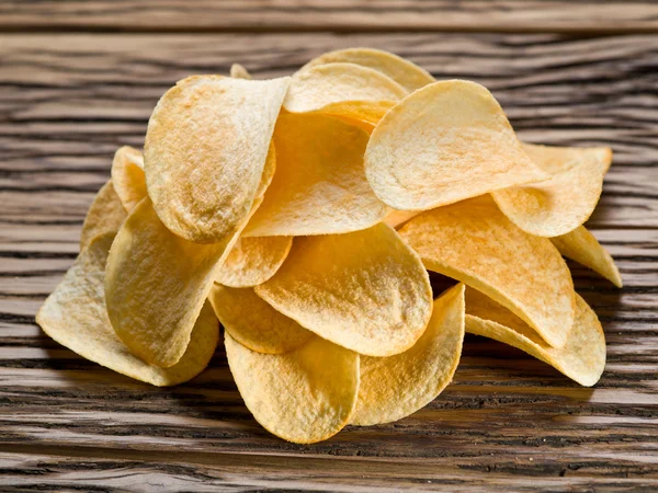 Batatas fritas em um fundo de madeira . — Fotografia de Stock