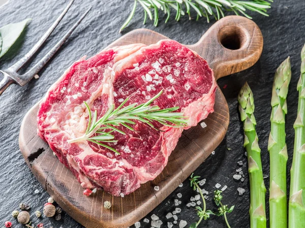 Rib eye steak met specerijen op de zwarte achtergrond. — Stockfoto