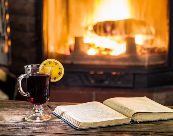 Vino rimuginato caldo e un libro sul tavolo di legno . — Foto Stock