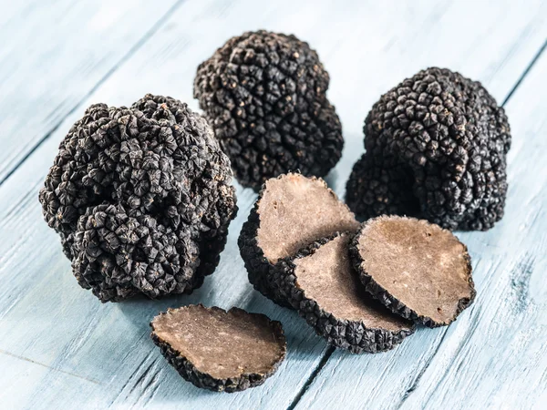 Black truffles on the old wooden table. — Stock Photo, Image