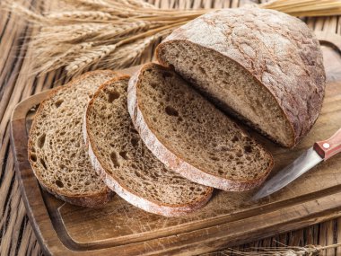 Siyah ekmek üzerinde ahşap tahta dilimlenmiş.
