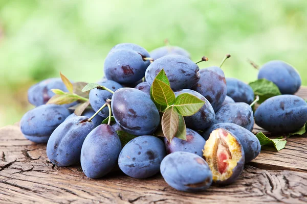 Pruimen op een oude houten tafel. — Stockfoto