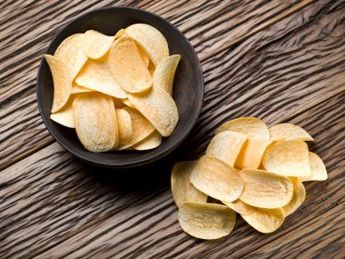 Tahta arka planda patates cipsi..