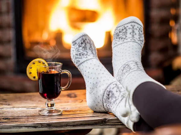 Aquecimento e relaxamento perto da lareira com uma xícara de vinho quente . — Fotografia de Stock