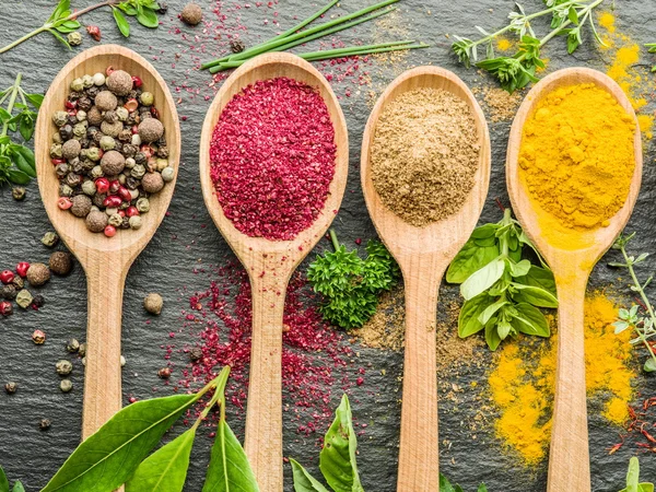 Assortment of colorful spices in the wooden spoons. — Stock Photo, Image