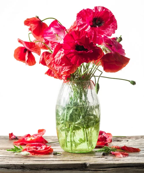 Букет маковых цветов в вазе на деревянном столе . — стоковое фото