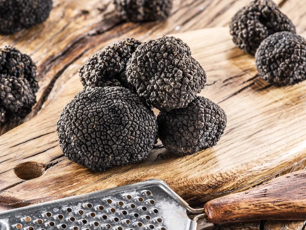 Trufas pretas na velha mesa de madeira. — Fotografia de Stock