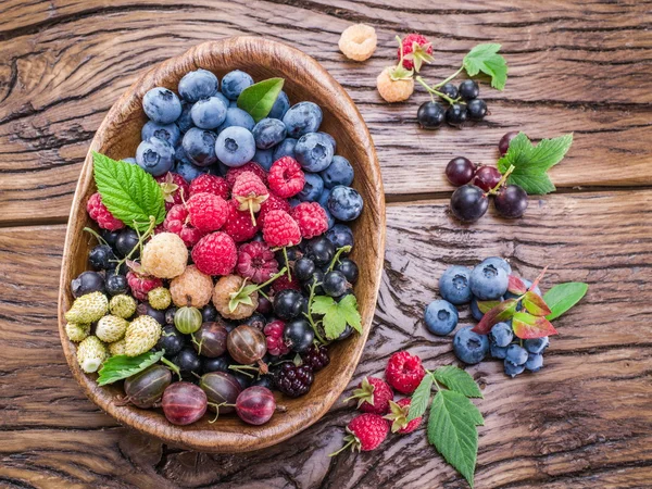 Ripe berries in the wooden bowl. — Stock Photo, Image