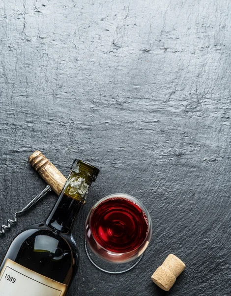 Vin flaska, glas vin och corkscrew i grafit styrelsen. — Stockfoto