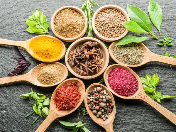 Assortment of colorful spices in the wooden spoons. — Stock Photo, Image