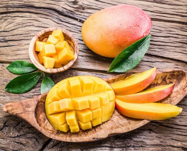 Mango fruit and mango cubes on the wooden table. — Stock Photo, Image