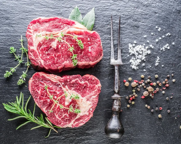 Rib eye steak, a fűszerek, a fekete háttér. — Stock Fotó