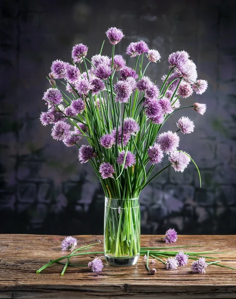 Bouquet di fiori di cipolla (erba cipollina) nel vaso sulla tavola di legno — Foto Stock