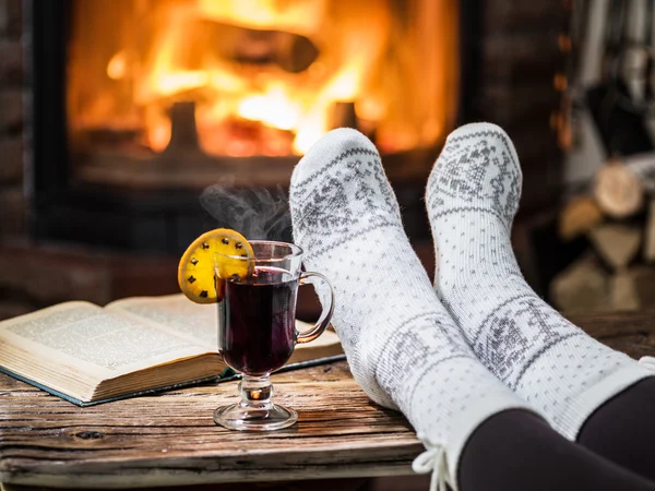 Riscaldamento e relax vicino al camino con una tazza di vino caldo e un — Foto Stock