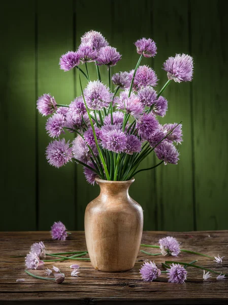 木制的桌子上的花瓶中的洋葱 （韭菜） 花束 — 图库照片