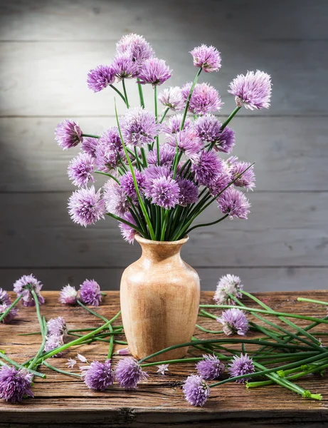 Bukiet z cebuli (szczypiorkiem) kwiaty w wazonie na drewniane tabl — Zdjęcie stockowe