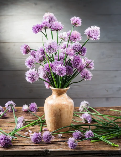 Bouquet of onion (chives) flowers in the vase on the wooden tabl — Stock Photo, Image