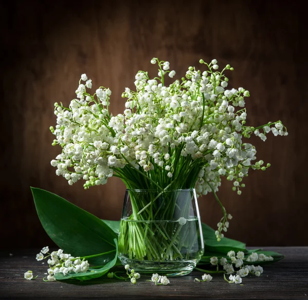 Lily of the valley bouquet on the wooden table. — Stock Photo, Image