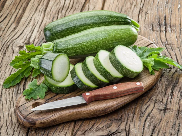 Zucchini with slices on a wooden table. — Stock Photo, Image
