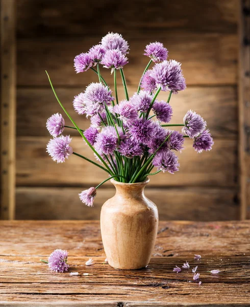 Bouquet of onion (chives) flowers in the vase on the wooden tabl — Stock Photo, Image