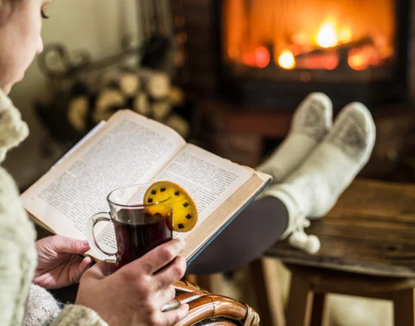 Horké svařené víno a knihou v rukou ženy. Odpočinek před bu — Stock fotografie