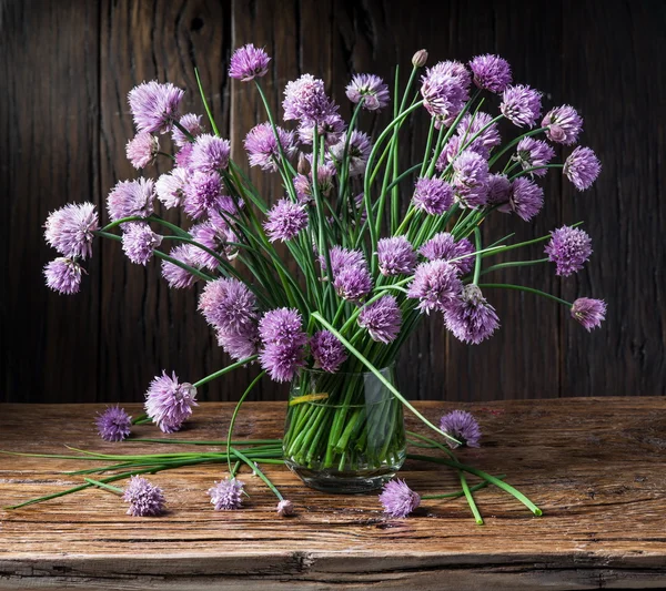 Bouquet of onion (chives) flowers in the vase on the wooden tabl — Stock Photo, Image