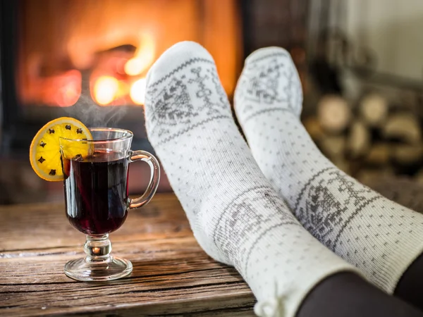 Aquecimento e relaxamento perto da lareira com uma xícara de vinho quente . — Fotografia de Stock