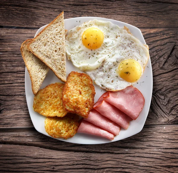 Śniadanie - smażone jajka z szynką i kawałki chleba. — Zdjęcie stockowe