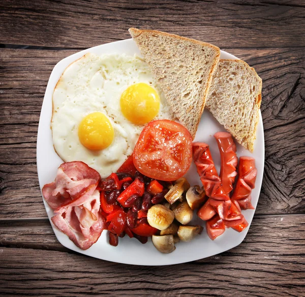 Traditional English breakfast - fried eggs, sausages, becon and — Stock Photo, Image