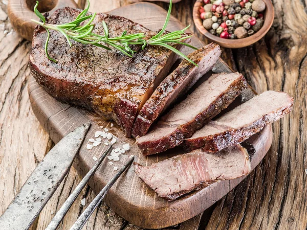 Biefstuk Ribeye met specerijen op de houten lade. — Stockfoto