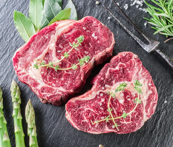 Rib eye steak met specerijen op de zwarte achtergrond. — Stockfoto