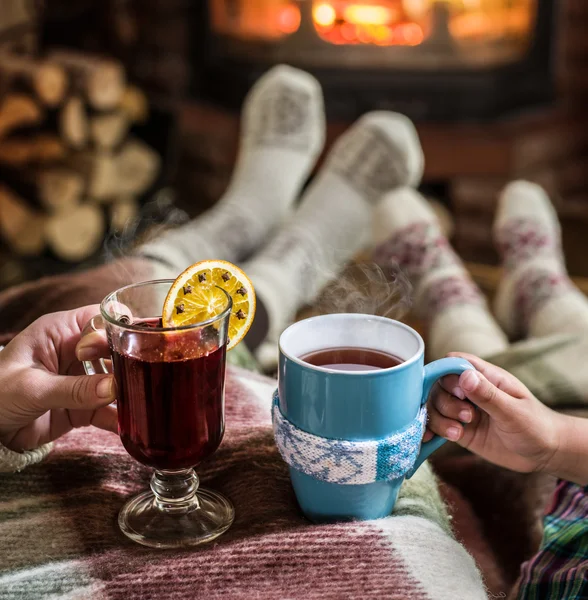 Oteplování a relaxaci u krbu se šálkem horké nápoje. — Stock fotografie