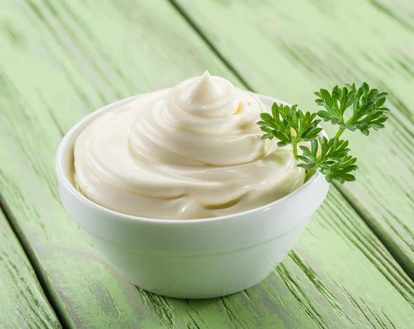 Mayonesa natural en el tazón blanco sobre la mesa de madera . — Foto de Stock