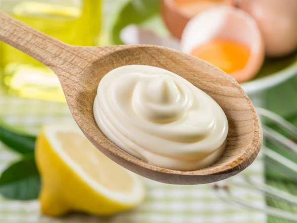 Natuurlijke mayonaise saus in de houten lepel en zijn ingrediënt — Stockfoto