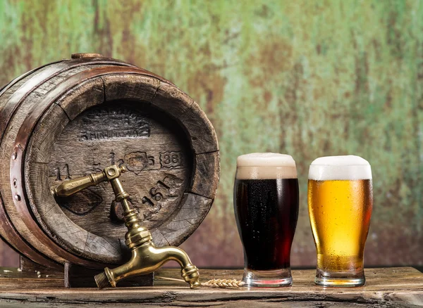 Copos de cerveja e barril de cerveja na mesa de madeira. Cervejaria artesanal — Fotografia de Stock