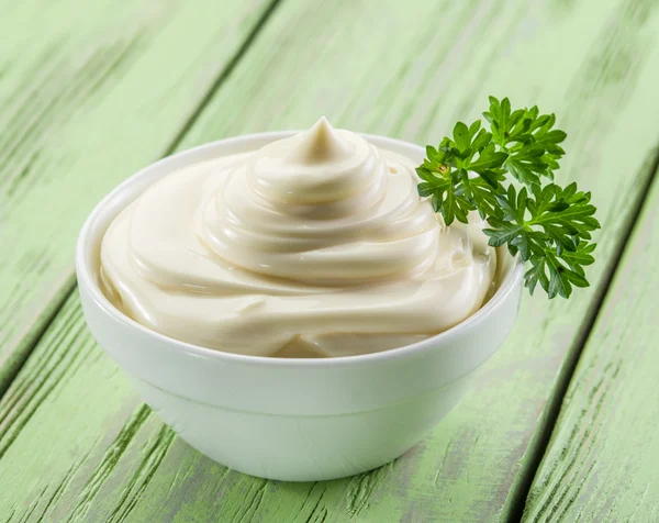 Natürliche Mayonnaise in der weißen Schüssel auf dem Holztisch. — Stockfoto