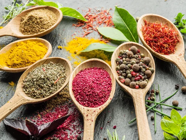 Assortment of colorful spices in the wooden spoons. — Stock Photo, Image