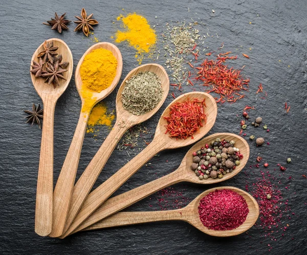 Sortiment av färgglada kryddor i träskedar. — Stockfoto