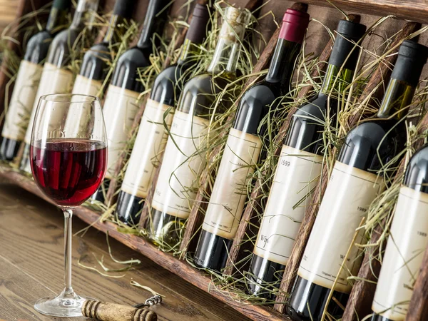 Glasflaskor för vin på en trähylla. — Stockfoto