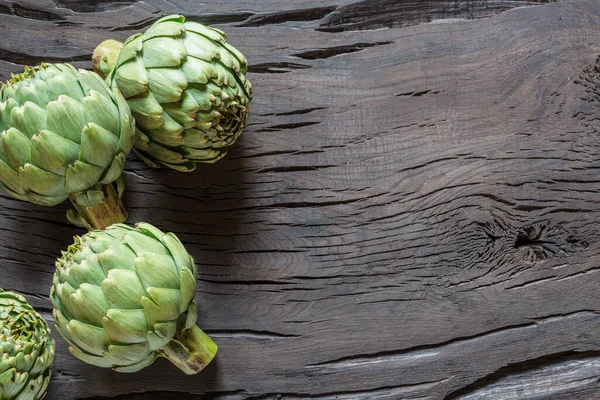 Bunga Hijau Artichoke Tunas Dimakan Pada Latar Belakang Kayu — Stok Foto