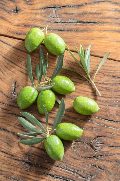 Aceitunas Naturales Verdes Con Hojas Olivo Sobre Una Mesa Madera —  Fotos de Stock