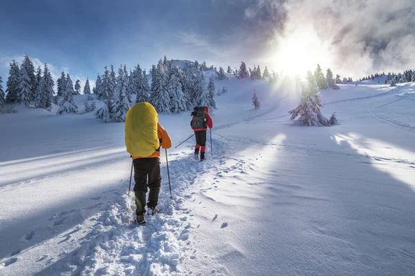 2人の観光客が雪を登る屋根付きの冬の山 晴れた日と雪の周りの多く — ストック写真