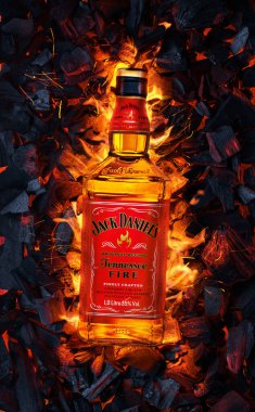 Ukrayna, Kiev. 12 Kasım 2020. Bir şişe Jack Daniels Whiskey Tennessee Fire yanan kömürlerin üstünde.