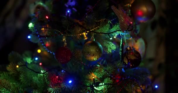 Karácsonyi sokszínű bokeh fények egy díszített lucfenyőn este. Koncepció - Szilveszter és Szenteste. Közelkép a karácsonyi bálokról.