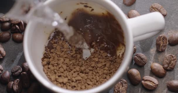 沸騰した水は インスタントコーヒー スローモーション クローズアップトップビューの顆粒上の白いカップに注がれます 300Fps Blackmagic Ursa Pro — ストック動画