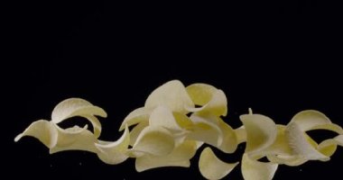 Doğal patates cipsi siyah arka planda yükselip alçalır. Yavaş Hareket 300 fps Blackmagic Ursa Pro G2.