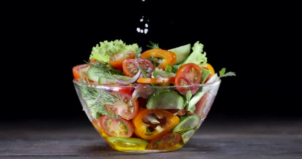 Insalata Verdure Fresche Una Ciotola Vetro Fondo Nero Cosparsa Sale — Video Stock