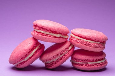 Renkli, tatlı badem kurabiyeleri, mor arkaplanda aromalı kurabiyeler..