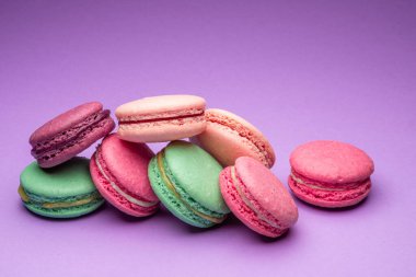 Renkli, tatlı badem kurabiyeleri, mor arkaplanda aromalı kurabiyeler..